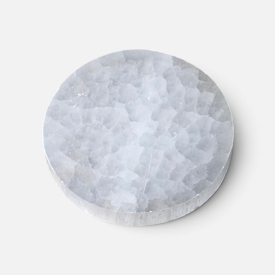 Assiette ronde en sélénite polie avec motifs spirituels gravés pour cristaux et bijoux.