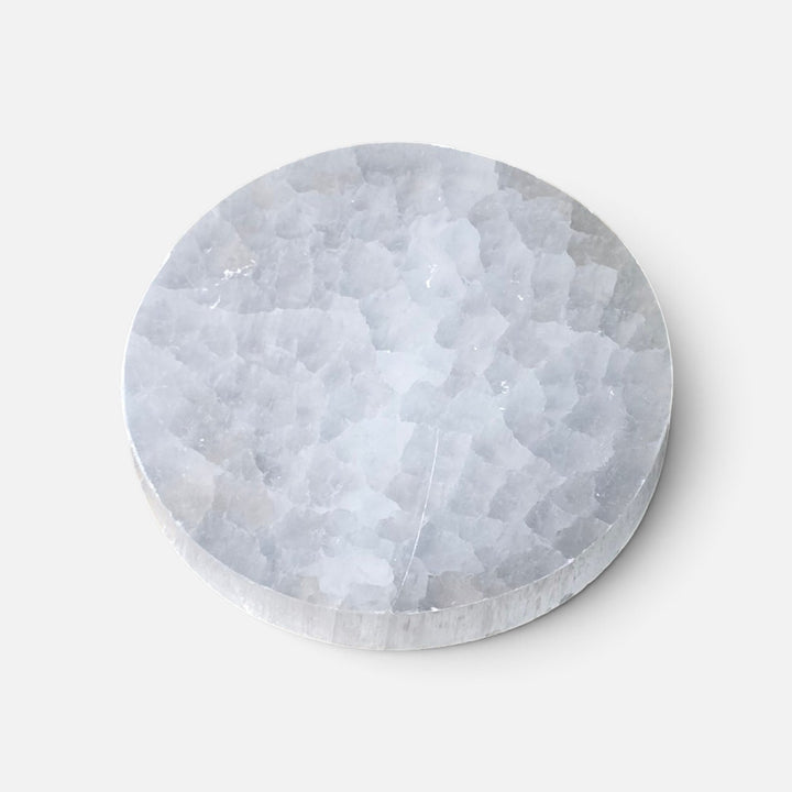 Assiette ronde en sélénite polie avec motifs spirituels gravés pour cristaux et bijoux.