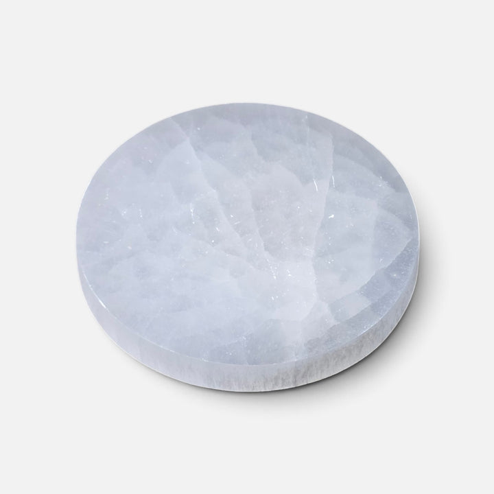 Assiette ronde en sélénite polie ornée d’un motif zodiacal pour décoration et cristaux. 12 à 14 cm.