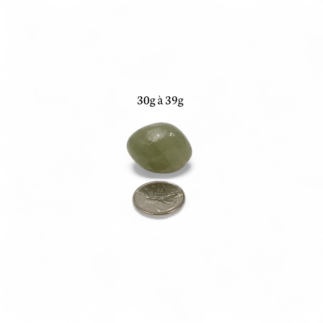 Pierre roulée Aventurine verte d’Inde, entre 30g et 39g, placée à côté d’une pièce de 25 cents pour illustrer ses dimensions.