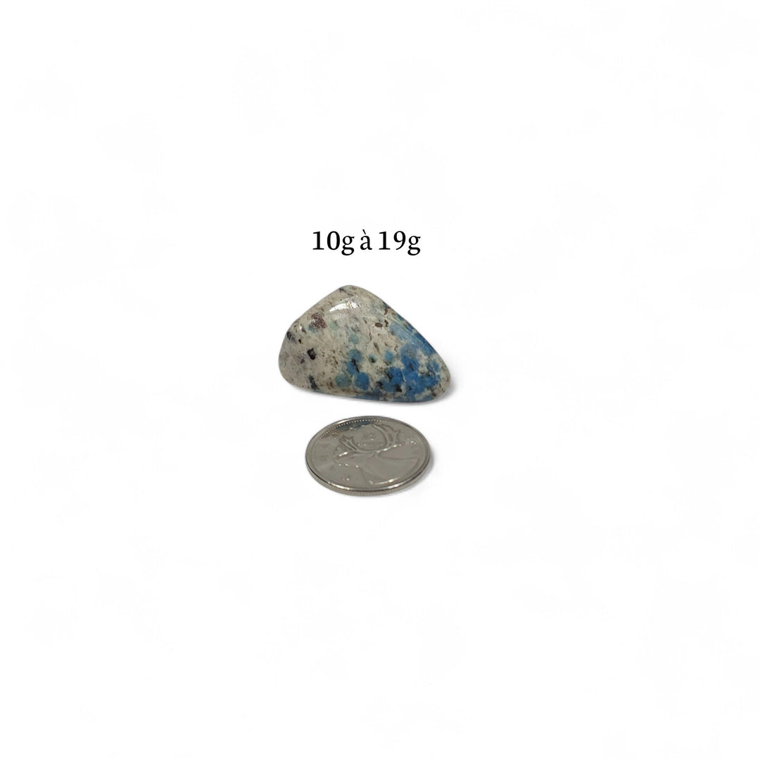 K2 roulée pesant entre 10g et 19g, pierre de communication et de clarté présentée avec pièce de 25 cents pour repère.