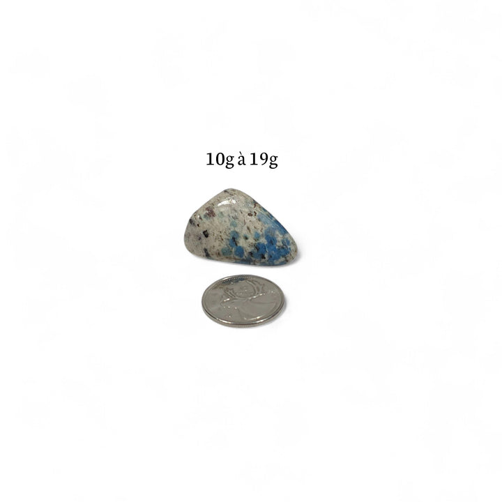 K2 roulée pesant entre 10g et 19g, pierre de communication et de clarté présentée avec pièce de 25 cents pour repère.