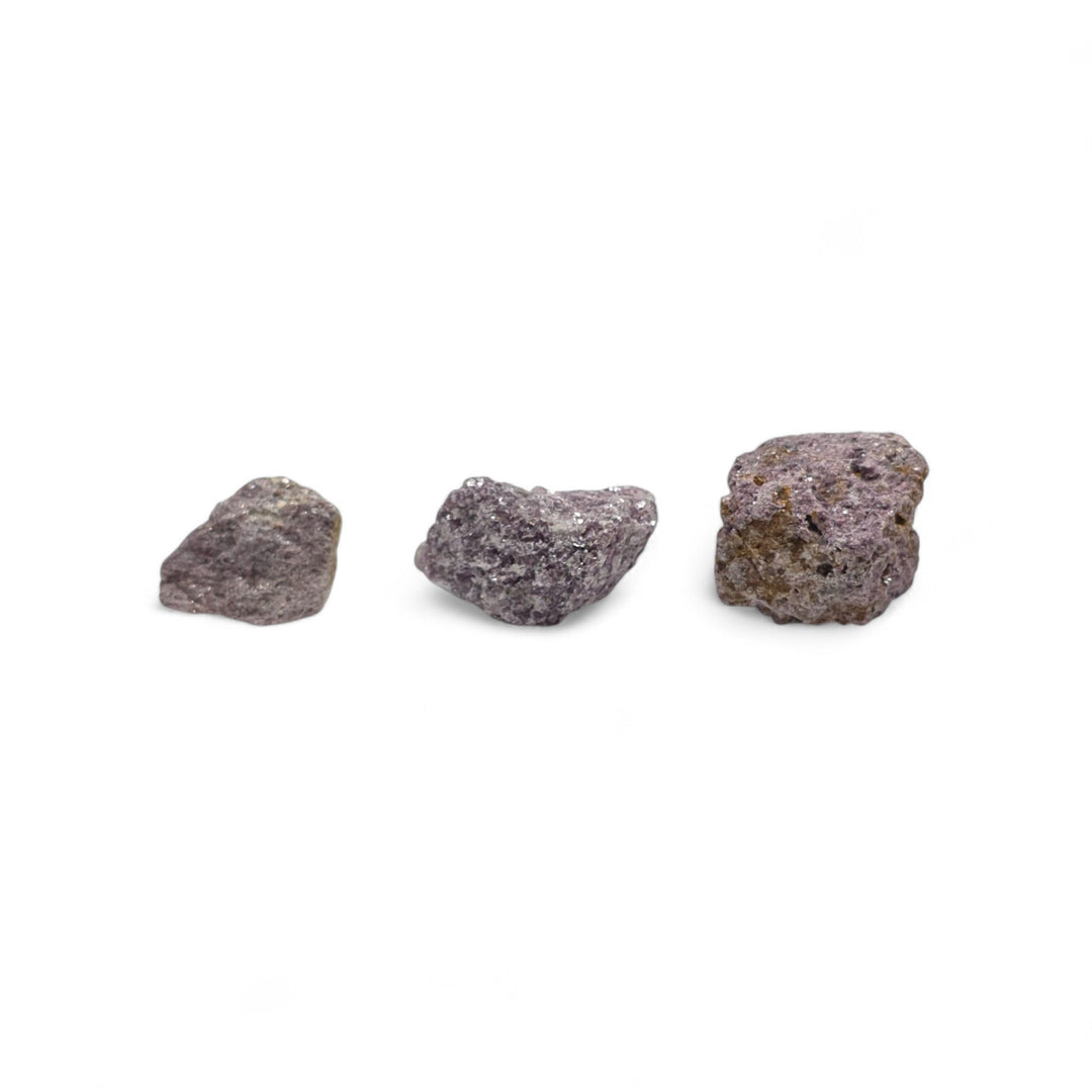 Lépidolite brute en trois tailles différentes, placées côte à côte pour comparaison visuelle et aperçu des variations de grosseur.