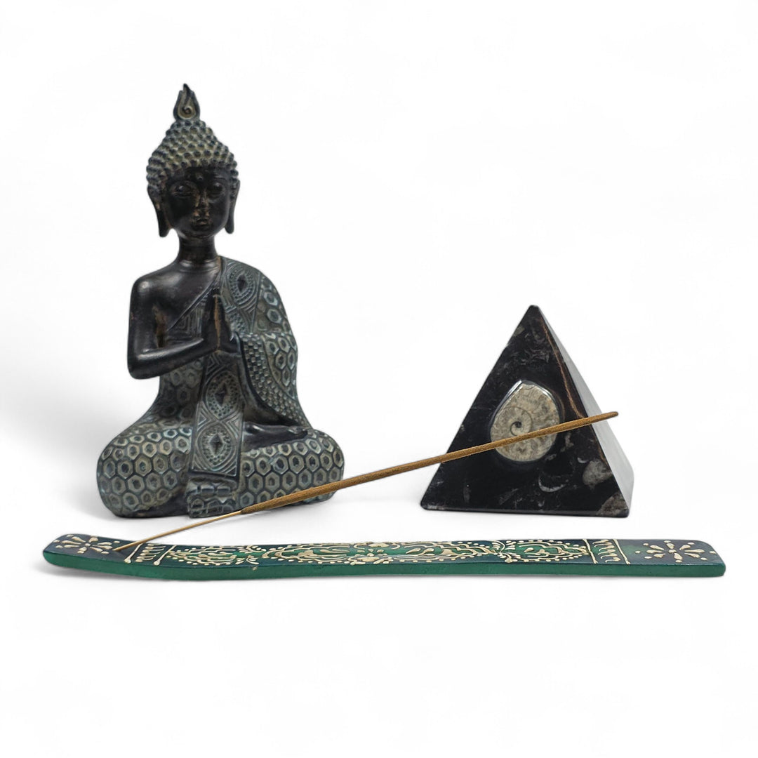 Porte-encens en bois avec bâtonnet et décorations, créant une ambiance douce et apaisante de démonstration.